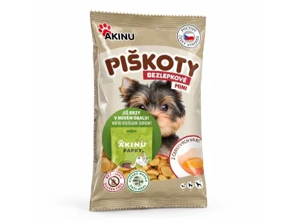 Packshot SKU 173010 (Akinu Bezlepkové Mini piškoty 120 g) — sólo na bílém, 2k 1:1, náklon podle skillu (~15°, pravá strana vpředu). Obal: aktuální Piškoty se samolepkou „Již brzy v novém obalu“ (reference asset d8615b68 nahraná uživatelkou) — maketa PAPKY v Heliosu je nový design, zatím nepoužita. Vybrána v2 ze 2.