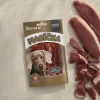 Flat-lay pro řadu Masíčka (SKU 204810) — travertinová deska, asymetrická kompozice syrového kachního masa. Vytvořeno stejným postupem jako referenční SKU 204809.