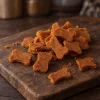 Solo surovina Akinu MASÍČKA Kuřecí kostičky s karotkou 300 g (204862) — pamlsek psi/kočky, hromádka na tmavém prkénku, realistický styl.