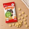 Flat-lay SKU 173009 — sáček shora na světlém dubovém stole s rozloženými mini piškoty, kompozice dle flat-lay 173011 (5e853864). Obal se samolepkou (b4dd53f3), surovina Helios doc 213622. 2k 1:1, v1 ze 2.