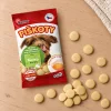 Flat-lay SKU 204599 — sáček shora na světlém dubovém stole s rozloženými piškoty, kompozice dle flat-lay 173011 (5e853864). Obal se samolepkou (3e54cc44), surovina Helios doc 196153. 2k 1:1, v2 ze 2.