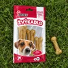 Flat-lay shora na trávě: sáček Žvýkadlo PAPKY se 3 buvolími kostmi 8 cm (204048) a vedle volně ležící jedna kost.