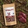 Flat-lay Srnec jerky 176166 – sáček + syrové srnčí maso na lesním jehličí.