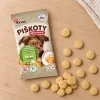 Flat-lay SKU 173011 (Akinu Bezlepkové piškoty 120 g) — sáček shora na světlém dubovém stole s rozloženými piškoty, kompozice podle flat-lay 173010 (fbe80fba). Obal se samolepkou (8f26e1bd), surovina Helios doc 213640. 2k 1:1, vybrána v2 ze 2.