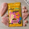Flat-lay shora: sáček Kuřecí chipsy 176227 uprostřed, kolem syrová kuřecí prsa (plátky + kostičky), podklad kuchyňská linka