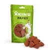 Packshot se surovinou Akinu PAPKY Srdíčko červené pamlsek pro psy 100 g (174028) — obal natočený podle vzoru 174027, vpravo dole před ním hromádka pamlsku. Styl jako řada Masíčka Premium.