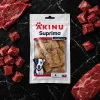 Flat-lay Akinu SUPRIMO SELECTION Dental pamlsek pro psy 75 g (282042) — režim produkt + suroviny (jen syrové hovězí maso dle pokynu Žanet, bez hrachu/řas), Nero Marquina mramor dle pravidla řady Suprimo, evergreen, 1:1, varianta v1 ze 4 (schválená).