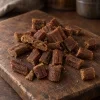 Solo surovina Akinu MASÍČKA Jehňečí kousky 300 g (282061) — hromádka na tmavém prkénku. Reference suroviny převzata z 204815 (přebalovaný produkt, potvrzeno uživatelkou) — 282061 nemá v Heliosu štítek Surovina.